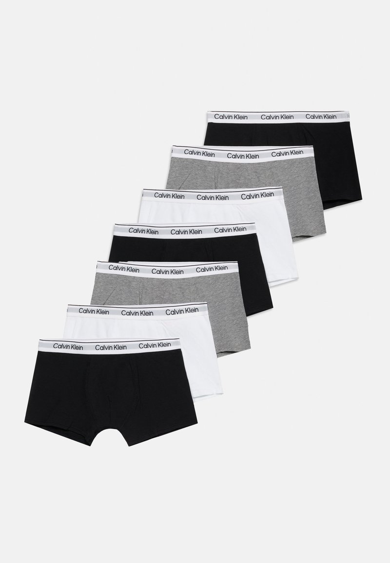 Επτά ζευγάρια εσώρουχα μπόξερ Calvin Klein σε μαύρο, λευκό και γκρι, τοποθετημένα διαγώνια με λευκές μέσες με το λογότυπο.