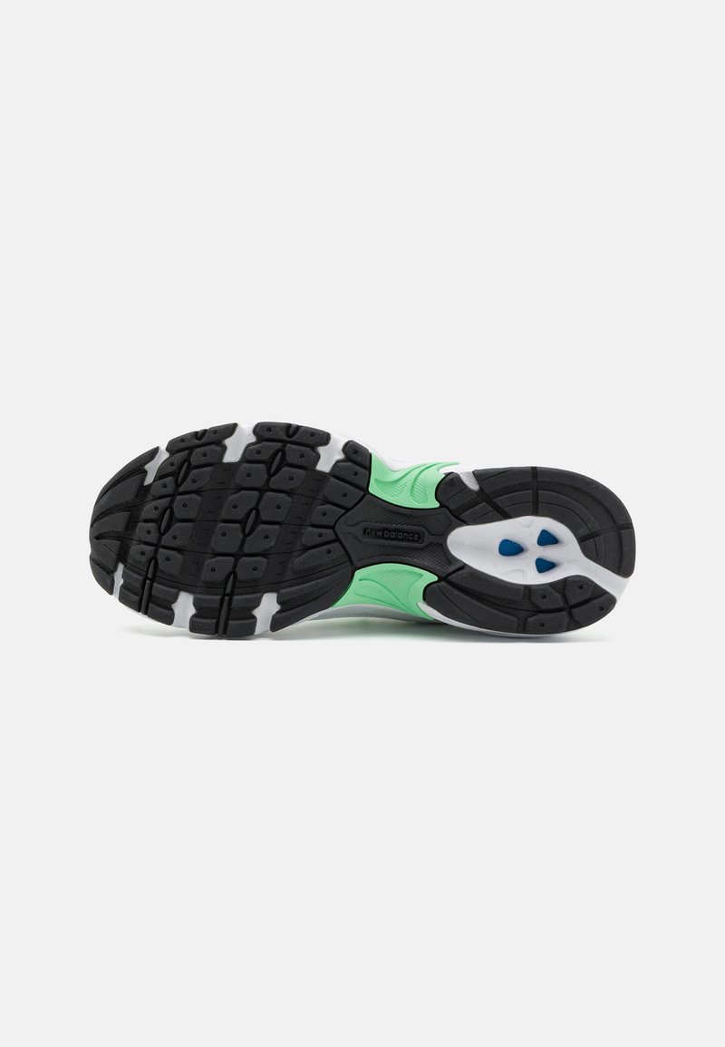 Suela de zapatilla de goma negra con acentos verdes, que presenta un patrón de banda de rodadura multidireccional, una media suela blanca y un detalle azul cerca del talón.