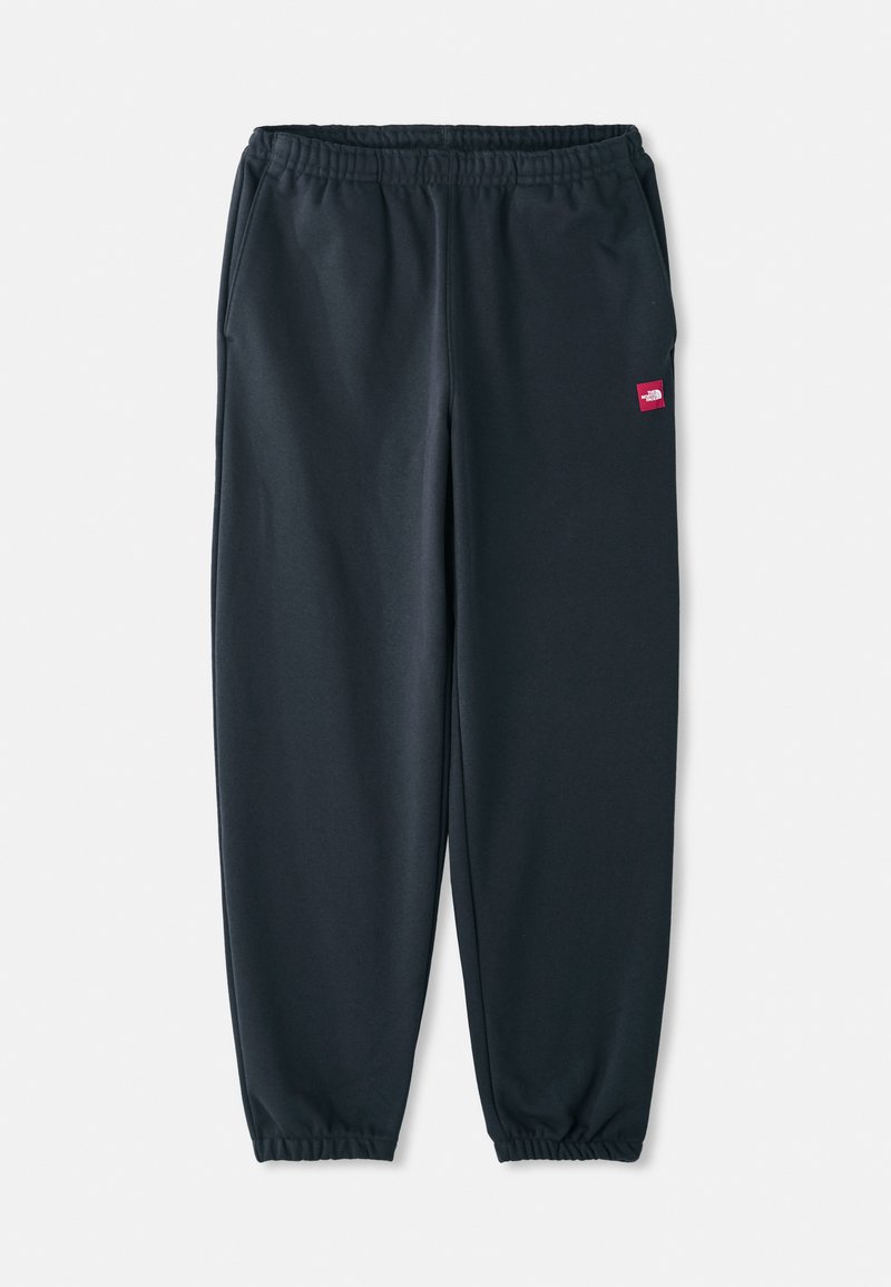 Sorte joggerbukser fremstillet af glat stof, med elastisk talje, ankelsøm og en lille rød logo patch på siden.