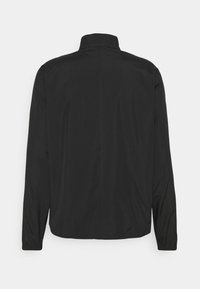 Veste noire à manches longues avec col montant, poignets élastiques et ourlet droit, vue de dos sur un fond blanc uni.