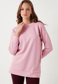 Felpa a maniche lunghe di un delicato color rosa pallido, con scollatura rotonda e polsini a coste. Presenta una vestibilità comoda e una texture morbida.
