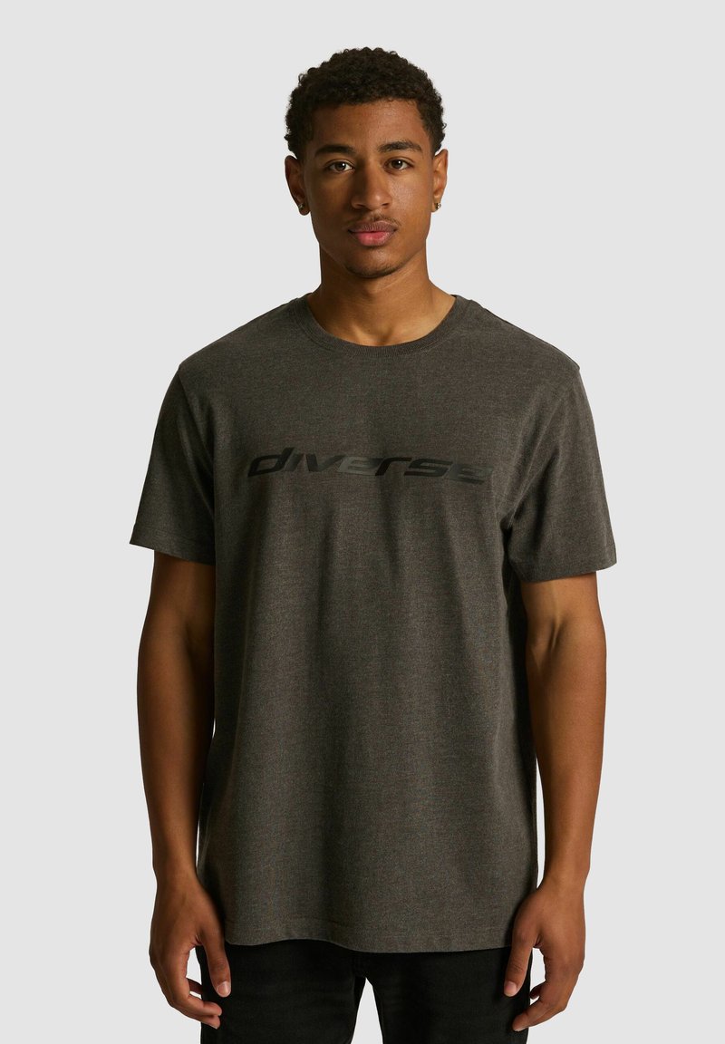 Szara bawełniana koszulka z krótkim rękawem i okrągłym dekoltem, z czarnym logo "diverse" na piersiach. Standardowy fason, gładka tekstura.