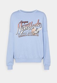 Ljusblå sweatshirt tillverkad av mjukt tyg med ett grafiskt tryck som visar "New York" och atletiska motiv. Lös passform med ribbade ärmar och nederkant.