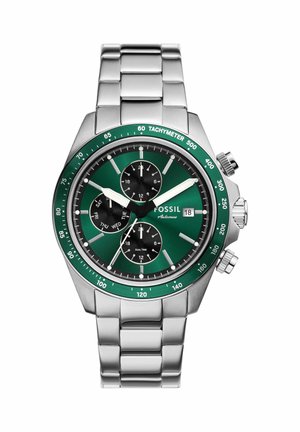 Sølvfarvet metal Fossil armbåndsur med grøn tachymeter bezel, grøn urskive, tre sorte subskiver, datovisning og tre kontrolknapper på siden.