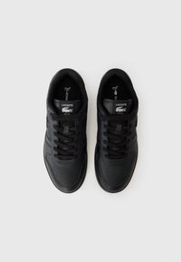 Black sneakers with a smooth leather upper, perforated toe, flat laces, and subtle blue accents. Lacoste branding on the tongue and side.