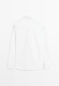 Camicia bianca a maniche lunghe con una texture liscia, colletto classico, polsini con bottone e una piega centrale sul retro per una vestibilità strutturata.