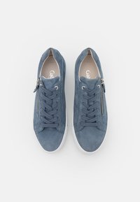 Modré semišové tenisky se šněrováním vpředu, bočním zipem a bílou gumovou podrážkou. Hladký povrch a zaoblený design špičky.