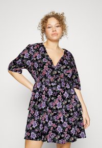 Vestido preto floral com mangas curtas bufantes, decote em V e barra com camadas de babados. Apresenta padrões de flores roxas e cor-de-rosa sobre um fundo escuro.