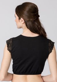 Schwarzes Cropped Top mit Spitzendetails an den Ärmeln, das einen figurschmeichelnden Oberkörper und einen gerafften Saum für eine enganliegende Silhouette aufweist.