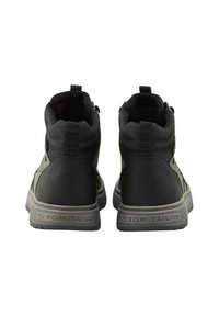 Botas negras hasta el tobillo con un upper de tela texturizada, talón reforzado y suela de goma. Presenta acentos de costura y un logo en el talón.
