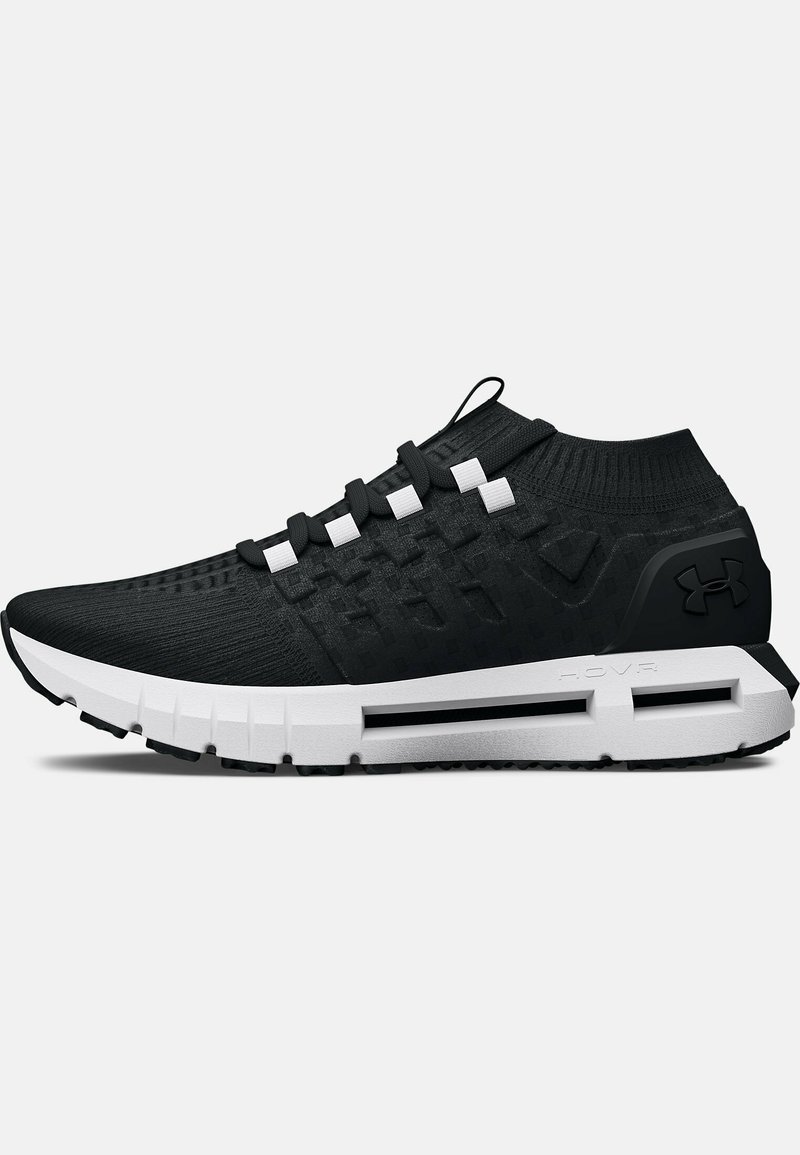 Zapatillas deportivas negras con un upper texturizado, acentos blancos y una suela gruesa con un patrón de relieve distintivo. Diseño ligero para mayor flexibilidad.