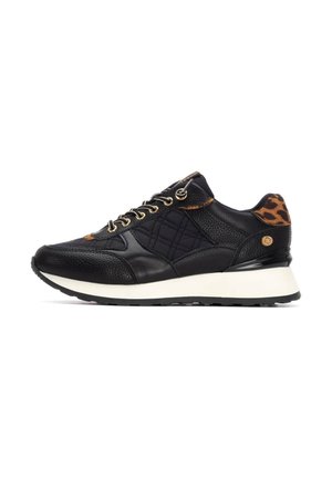 Zapatilla negra con un upper de cuero texturizado y tejido acolchado, que presenta acentos de estampado de leopardo, ojales dorados y una entresuela blanca.