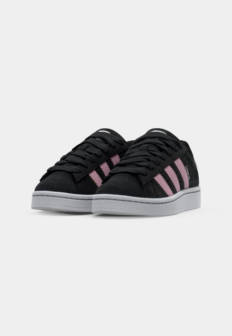 Sneakers in suede nero con accenti rosa a tre strisce, punta rotonda, suola piatta in gomma grigia e chiusura tradizionale con lacci.
