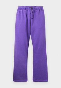 Lilla joggebukser med drakksnor i midjen, laget av myk stoff. De har en løs passform og rette ben uten lommer.