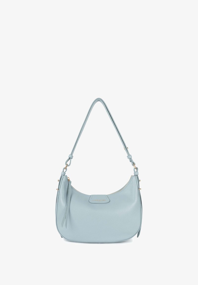Sac à épaule en cuir bleu clair avec une forme courbée, un dessus zippé et une étiquette en métal doré. Présente une seule sangle ajustable.