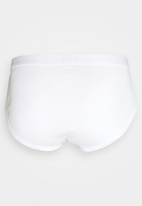 Hvide bomuldsunderbukser med en glat overflade og en blød elastisk talje. Ingen mønstre eller accenter. Har et buet design bagtil for bedre pasform.