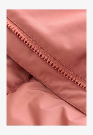 Nedidelis, švelnus rožinis audinys su lygia užtrauktuko dalimi, turinčia apvalius dantukus. Medžiaga atrodo lengva ir šiek tiek blizganti.