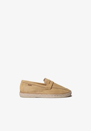 Svetlohnedý semišový mokasín na nazutie s tkanou podrážkou v espadrilovom štýle, dekoratívnym remienkom cez hornú časť a viditeľnými detailmi šitia.
