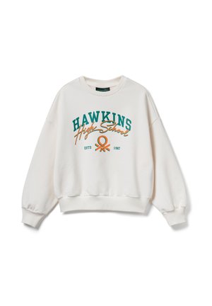 Sweat-shirt blanc avec texte "Hawkins High School" en vert et orange, un emblème, et "ESTD 1987" imprimé à l'avant.