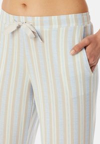 Leichte, gestreifte Loungewear-Hosen mit einem Kordelzugbund, Fronttaschen und abwechselnd cremefarbenen und blauen vertikalen Streifen mit feinen Details.