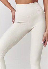 Legginsy o wysokim stanie, prążkowane w jasnym odcieniu beżu. Posiadają bezszwowy krój i gładką fakturę, idealne dla komfortu i elastyczności.