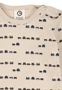 Body beige a maniche lunghe con un motivo giocoso di treni in blu scuro, nero e rosso. Tessuto morbido con chiusura a scatto sulla spalla.