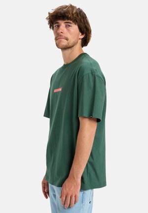 Green cotton t-shirt with a crew neck, short sleeves, and a red logo detailing on the front. Casual fit, soft texture, minimal design.