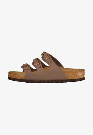 Sandalo marrone slip-on con tre cinghie regolabili e hardware tono rame. Sottopiede in sughero e suola in gomma testurizzata per una presa migliore.