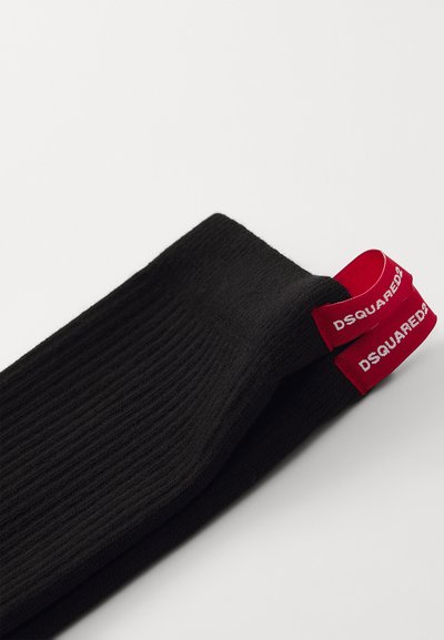 Sorte ribbestrikkede sokker med røde elastiske manchetter og trykt "DSQUARED2" logo. Materialet ser blødt og strækbart ud, ideelt til komfort.