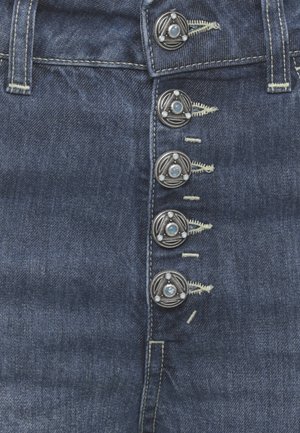 Jean denim bleu foncé avec cinq boutons métalliques décoratifs arborant un motif triangulaire et des boutonnières cousues.