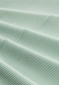 Tkanina s prugama u zelenoj i bijeloj boji, s glatkom teksturom, prikazana u mekanim naborima koji ističu uzorak i kontrast boja.