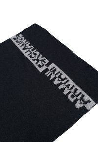 Sciarpa nera lavorata a maglia con un motivo testuale grafico grigio al centro, con una consistenza liscia e forma rettangolare.