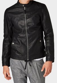 Czarna kurtka z imitacji skóry ze stójką, ukośnymi szwami i prążkowanymi wstawkami na ramionach. Przód zapinany na zamek oraz dwie boczne kieszenie.