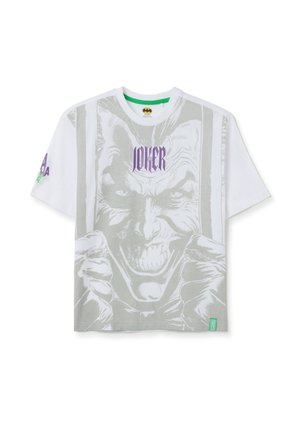 White short-sleeve T-shirt featuring a large gray Joker graphic on the front. "JOKER" text in purple above the image. Green branding tag.