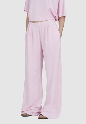 Pantalons larges rose clair en tissu doux et pelucheux, dotés d'une coupe décontractée, d'une taille élastique et de poches latérales.