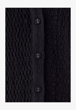 Must tekstuuriga kardigan, millel on kortsus muster, viis kangaga kaetud nööpi ees, sileda viimistluse ja peene läikega.