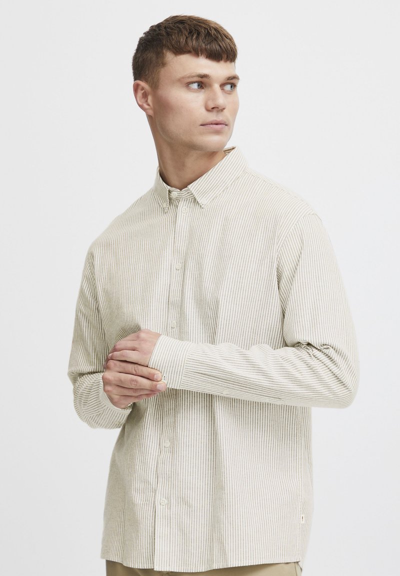 Stribet langærmet skjorte i blød beige og lys grønne nuancer, med button-down krave og manchetter, samt en afslappet pasform.