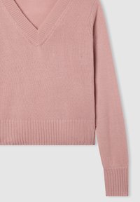 Różowy sweter z długim rękawem, dziany, z dekoltem w kształcie V oraz prążkowanym dolnym brzegiem i mankietami, na jasnoszarym tle.