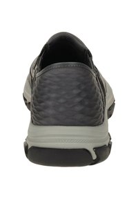 Czarne sportowe buty o teksturowanej cholewce, szarymi akcentami, zaokrąglonym obcasem i elastyczną czarną gumową podeszwą. Lekka i wsuwana konstrukcja.