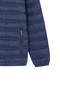 Jachetă puffer navy, cu textură ribbed, buzunar lateral cu fermoar, manșete elastice și linii orizontale cusute pentru izolație.