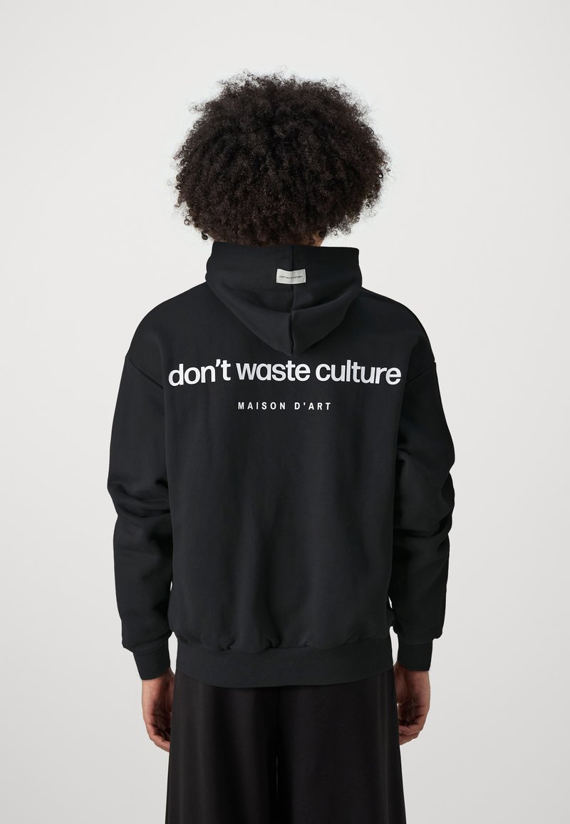 Schwarzer Hoodie, von hinten angezeigt, mit weißem Text "don't waste culture" und "MAISON D'ART." Enthält eine passgenaue Kapuze und gerippte Bündchen.
