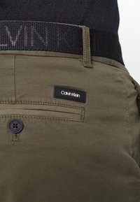 Calvin Klein GARMENT BELT - Chinos - forest night