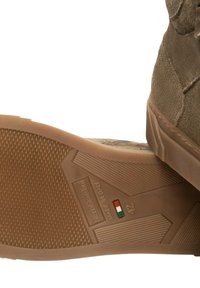 Brauner Wildlederstiefel mit texturierter Gummisohle, der ein Design zeigt, das "MADE IN ITALY" und die Größe 42 in roten, weißen und grünen Akzenten hervorhebt.