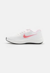 Zapatilla deportiva blanca con un upper texturizado, detalles en rosa, pequeño logo, diseño de cordones y suela de goma negra.