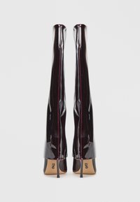 Stivali alti fino al ginocchio con tacco alto in vernice bordeaux lucida, caratterizzati da un design elegante e dettagli di cucitura verticale a contrasto.