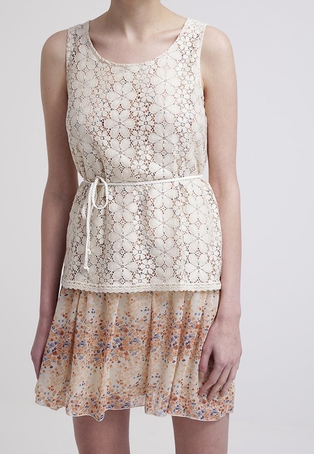 Lace top with floral pattern in beige, cinched at the waist with a white tie; layered, lightweight skirt in peach with multicolored floral accents.