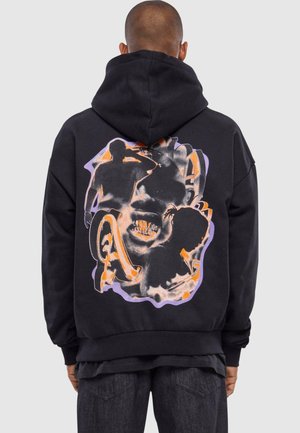 Sort hoodie med en stor, farverig grafik på ryggen, der viser silhuetter og abstrakte design i orange og lilla nuancer.