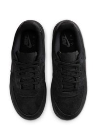 Melnas sporta apavi ar zamšas un tīkla augšējo daļu, apaļu purngalu, plakanām šņorēm un Nike logo sānos un iekšējās zolēs.