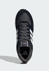 Baskets en suède noir et mesh avec des accents gris, dotées de trois rayures blanches, d'un col rembourré, d'un laçage à l'avant et d'une semelle intérieure ventilée.
