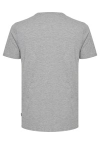 Camiseta gris de manga corta, cuello redondo, hecha de tela suave. Diseño simple con corte recto y sin patrones o acentos visibles.